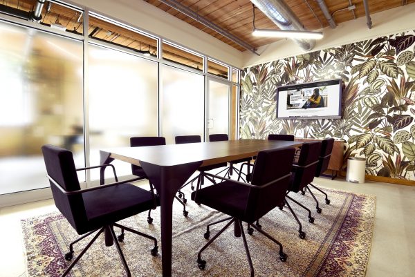 Meeting room with black chairs and floral wallpaper at Workplace One Queen