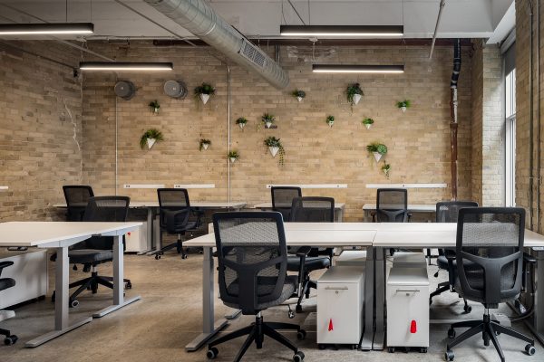 Team suite with open concept desks and brick walls